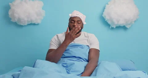 Dark skinned black plump man hates Monday morning awakes very early feels tired Stock Footage 148991647