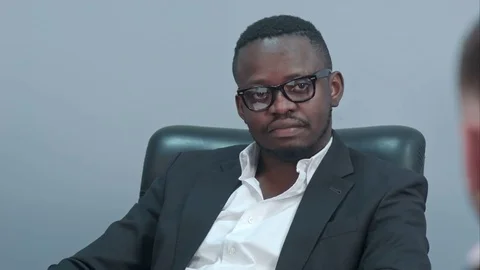 Dark-skinned businessman sitting at table and communicating with his caucasian 動画素材 76107357