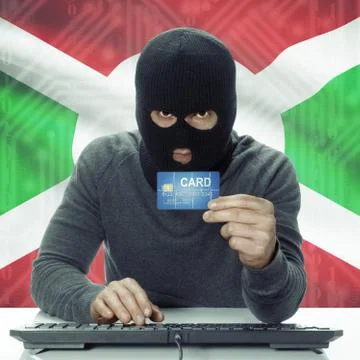 Dark-skinned hacker with flag on background holding credit card - Burundi 写真素材