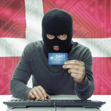 Dark-skinned hacker with flag on background holding credit card - Denmark 写真素材