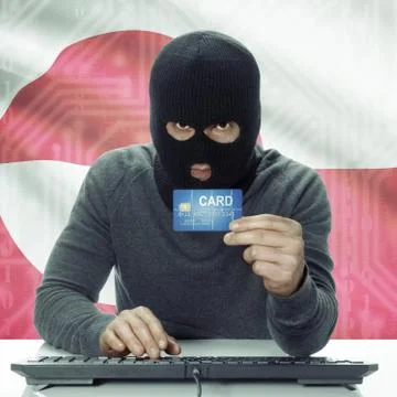 Dark-skinned hacker with flag on background holding credit card - Greenland Stockfoto's