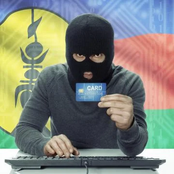 Dark-skinned hacker with flag on background holding credit card - New Caledon Photos