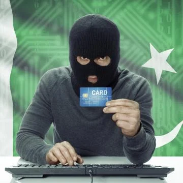 Dark-skinned hacker with flag on background holding credit card - Pakistan Фото