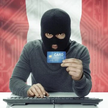 Dark-skinned hacker with flag on background holding credit card - Peru 写真素材