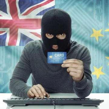 Dark-skinned hacker with flag on background holding credit card - Tuvalu Stock Photos
