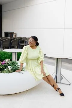 Dark-skinned lady laughs outside. Brunette woman in yellow dress smiles and.. Stock Photos