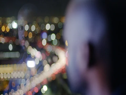 Dark skinned man looks over city lights and freeways in Los Angeles 4K Stock Footage 73100844