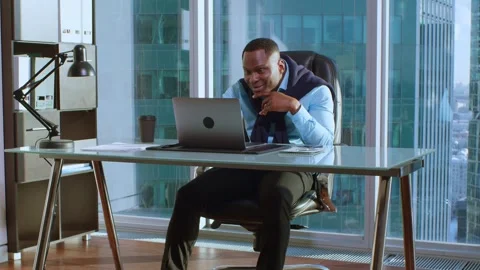 Dark-skinned man in the middle shot works in office in a skyscraper and rejoices Vidéo 262811154