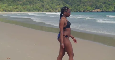 A dark-skinned model in a black bikini posing with a fierce expression on a Stock Footage 335121054