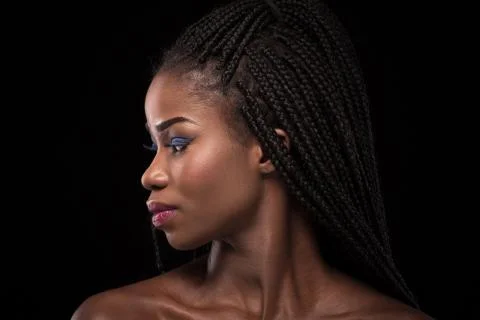 Dark skinned model with turning head to the left side on black backstage. Stock Photos