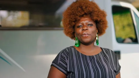 Dark-skinned smiling African young woman with kinky hair in front of her Stock Footage 205750520