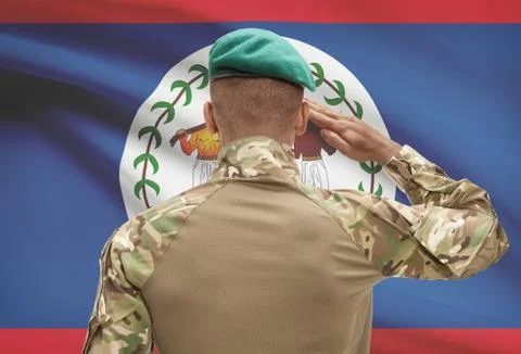 Dark-skinned soldier in hat facing national flag series - Belize 写真素材
