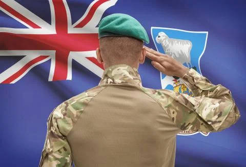 Dark-skinned soldier in hat facing national flag series - Falkland Islands Fotos de archivo