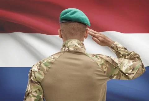 Dark-skinned soldier in hat facing national flag series - Netherlands 写真素材