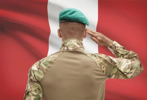 Dark-skinned soldier in hat facing national flag series - Peru Stock Photos