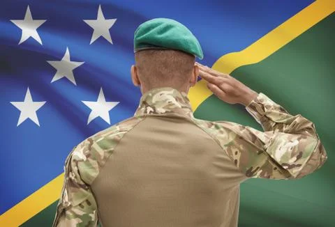 Dark-skinned soldier in hat facing national flag series - Solomon Islands Stock Photos