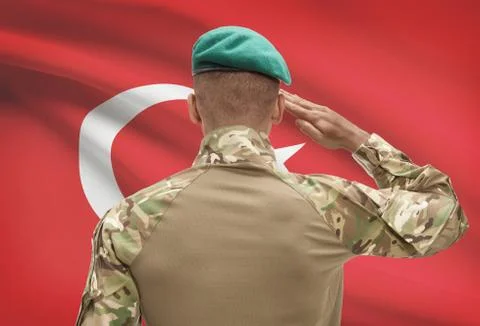 Dark-skinned soldier in hat facing national flag series - Turkey Fotos de archivo