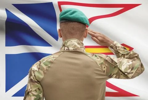 Dark-skinned soldier in hat facing Canadian province flag series - Newfoundla Stock Photos
