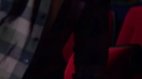 A dark-skinned young man gets up irritably and leaves the movie session, the Stockbeeldmateriaal 267349923