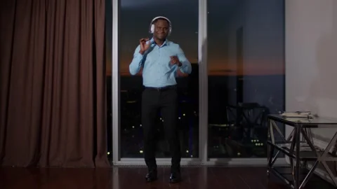 A dark-skinned young man in office classic clothes dances at sunset in a Vidéo 263394342