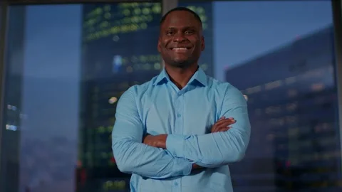 Dark-skinned young man stands in the middle ground with his arms crossed, a man Stock Footage 267534209