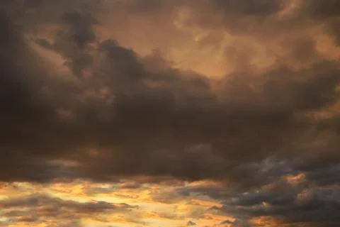 Dark sky with blak clouds brings storm rain at the sunset. Stock Photos