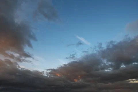 Dark sky with blak clouds brings storm rain at the sunset. Stock Photos