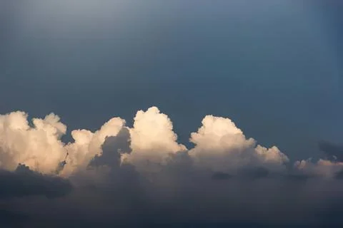 Dark sky with fluffy white clouds in the evening Stock Photos