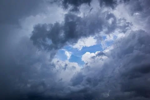 The dark sky had clouds gathered to the right and a strong storm before it ra Stock Photos