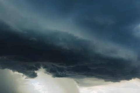 The dark sky had clouds gathered to the left and a strong storm before it rai Stock Photos