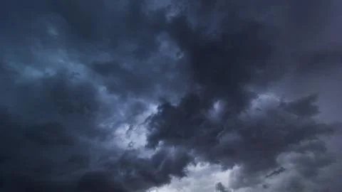The dark sky had clouds gathered to the right and a strong storm before it ra Stock Photos