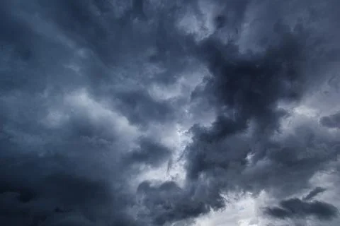 The dark sky had clouds gathered to the right and a strong storm before it ra Stock Photos