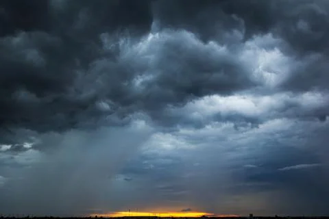 The dark sky had clouds gathered to the left and a strong storm before it r.. Stock Photos