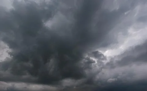 The dark sky had clouds gathered to the left and a strong storm before it r.. Stock Photos