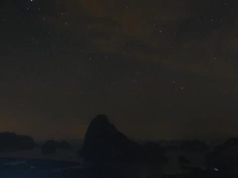 A dark sky with a mountain in the background Stock Photos
