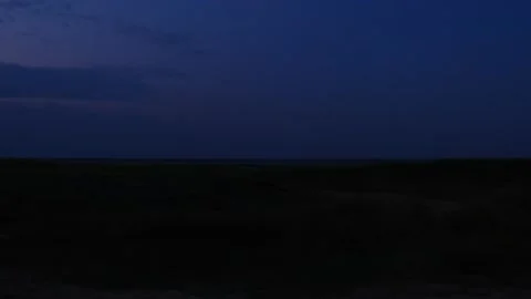 A dark sky with no clouds. Red lights flash on the wind turbines. Stock Footage 274065307