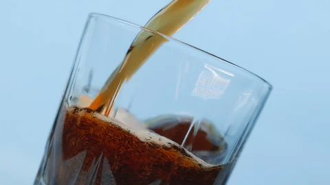 A dark soft drink slowly pours into a glass. Stock Footage 128092594