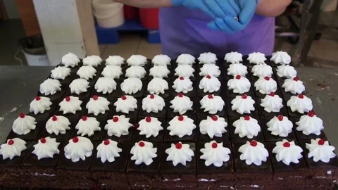 Dark sponge cakes with white cream decorated with a red berry Stock Footage 80587948