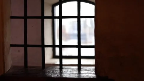 Dark stone prison inside a medieval castle, rusty bars, chains, 4K ultra HD. Stock Footage 321150562