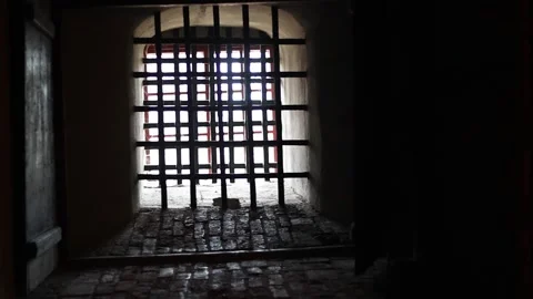 Dark stone prison inside a medieval castle, rusty bars, chains, 4K ultra HD. Video stock 321152912