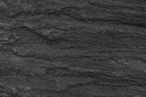 Dark stone texture with natural rough surface and layered structure Stock Photos