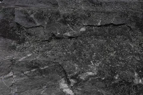 Dark stone texture with natural rough surface and layered structure. Stock Photos