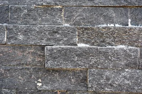 Dark stone wall texture featuring seamless rectangular patterns Stock Photos
