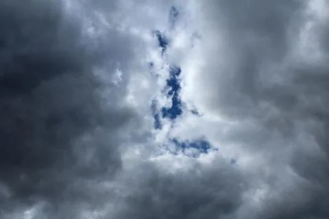 A dark storm cloud in the blue sky. Stock Photos
