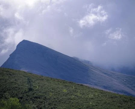 A dark storm cloud hides the mountains Stock Photos
