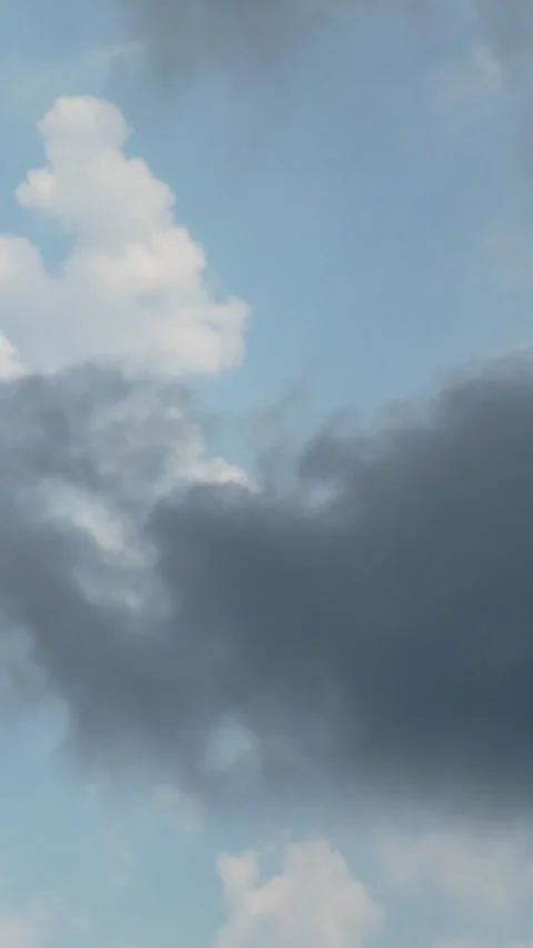 Dark storm cloud moves slowly across bright blue summer sky. Video stock 339013554