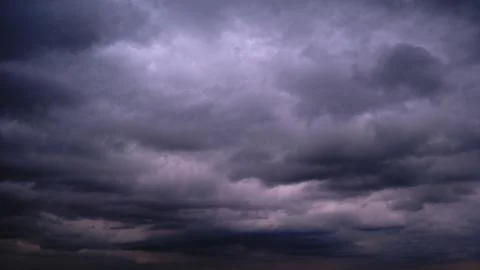Dark storm clouds in the evening sunset sky, timelapse. Dramatic sky with Stock Photos