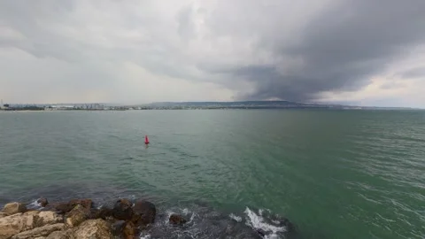 Dark storm clouds forming over the sea with city coastline in the background Stock Footage 318161725