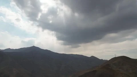 Dark storm clouds gather above silhouetted Chalus Road mountain ridges, Stock Footage 343907299