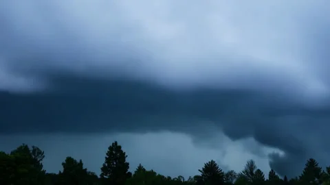 Dark storm clouds gather ominously in sky, impending downpour. Stock Footage 301709812